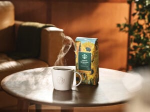 A mug with hot coffee next to Starbucks Sunsera coffee bag