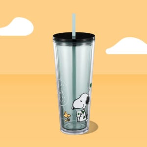 Starbucks and Peanuts cold cup with a straw on a yellow background