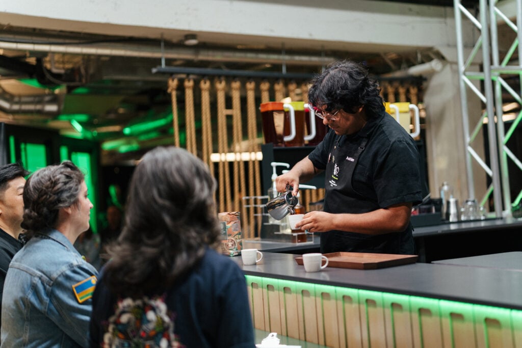 One of the Starbucks barista champions pouring coffee in front of an audience