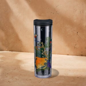 A tall, clear travel mug features colorful illustrations of a cauldron, plants, and whimsical elements against a dark background.