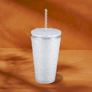 A textured, white tumbler with a clear lid and straw, featuring a raised logo design on the front, set against an orange background.
