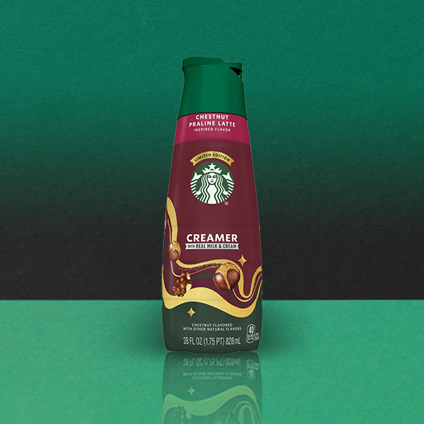 A bottle of Starbucks Chestnut Praline Latte Creamer, featuring a green cap and a maroon label, set against a gradient background.