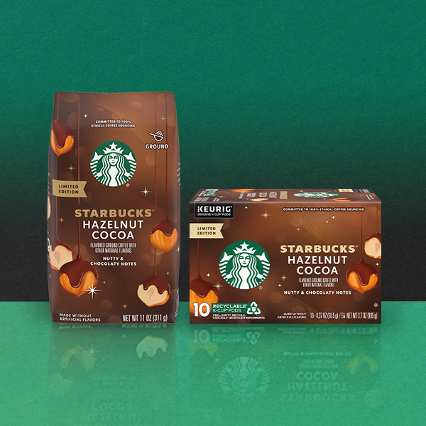 A bag of Starbucks Hazelnut Cocoa ground coffee and a box of Keurig-compatible pods, both featuring a limited edition design with nutty and chocolaty notes. The background is a gradient of green.