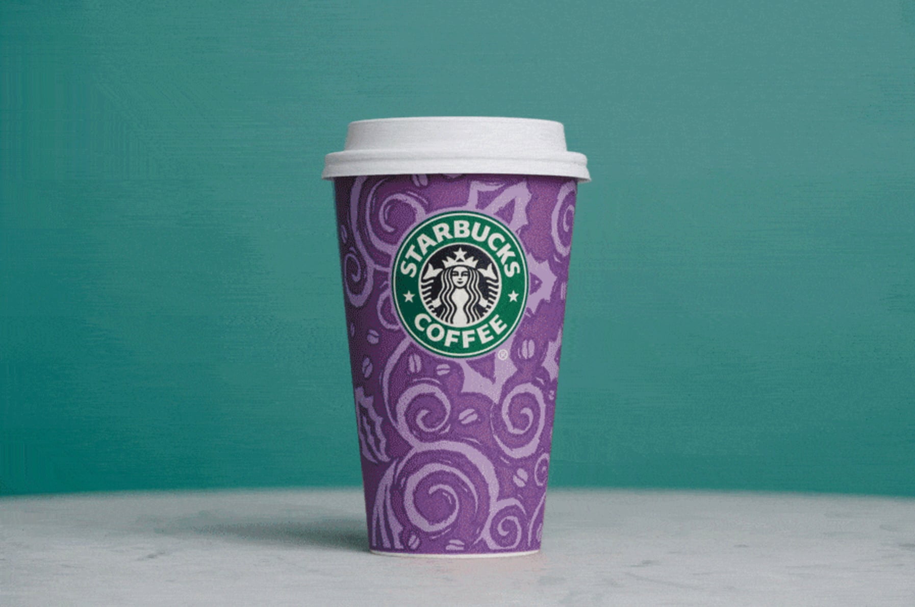 A purple Starbucks coffee cup with decorative swirls and the Starbucks logo prominently displayed, set against a teal background.