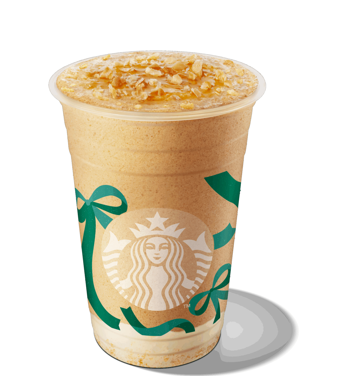A frosty beverage in a clear cup, topped with caramel drizzle and crunchy oat pieces, featuring the Starbucks logo and festive green ribbons.