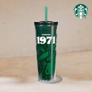 A tall, clear Starbucks tumbler featuring a green design with the year "1971" prominently displayed. It has a black lid and a green straw.