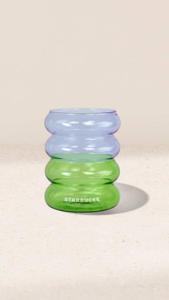 A stacked, three-tiered glass in green and blue hues, featuring the Starbucks logo at the base.