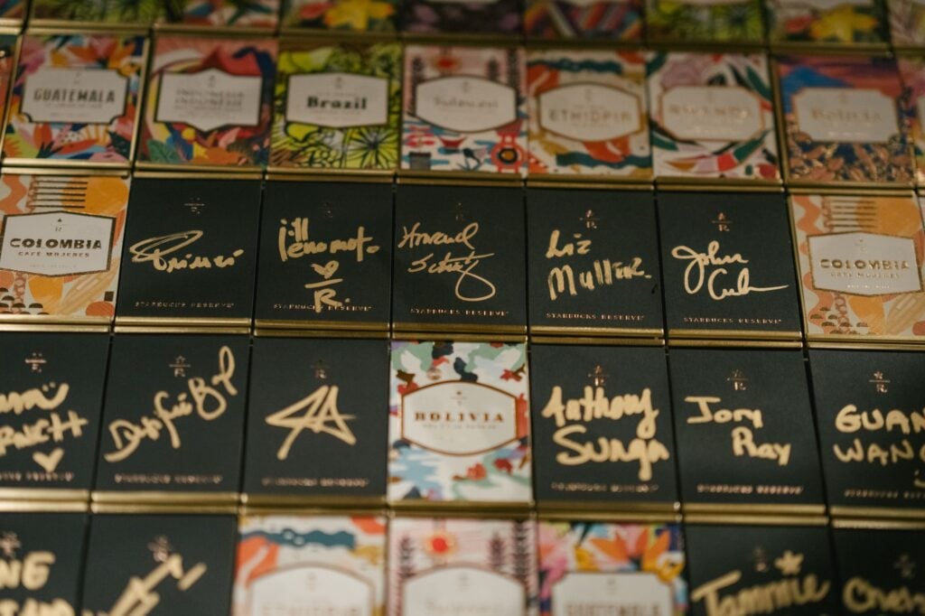 A collection of colorful coffee packaging from Starbucks Reserve, featuring various countries like Colombia, Brazil, and Bolivia, with signatures.
