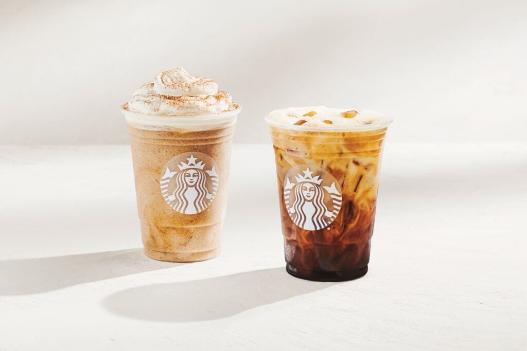 Two Starbucks beverages are displayed: a frosty, whipped cream-topped drink with a dusting of cinnamon on the left, and an iced coffee with visible ice cubes and a creamy layer on the right. Both cups feature the Starbucks logo.
