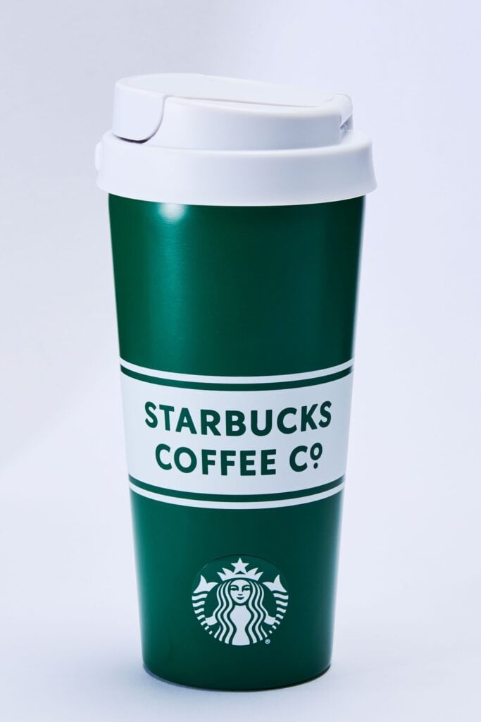 A green Starbucks coffee cup with a white lid and branding, featuring the logo and "STARBUCKS COFFEE CO." text.