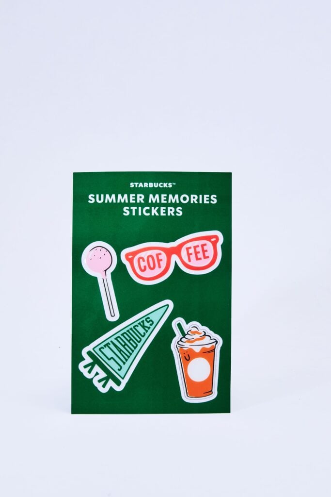 A green card features various colorful stickers, including a pink lollipop, red sunglasses with "COF FEE," a green pennant with "Starbucks," and an orange drink with whipped cream. The card is labeled "SUMMER MEMORIES STICKERS.