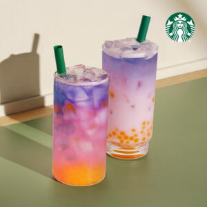 Two colorful drinks with ice, featuring vibrant layers of purple, pink, and orange, topped with green straws.