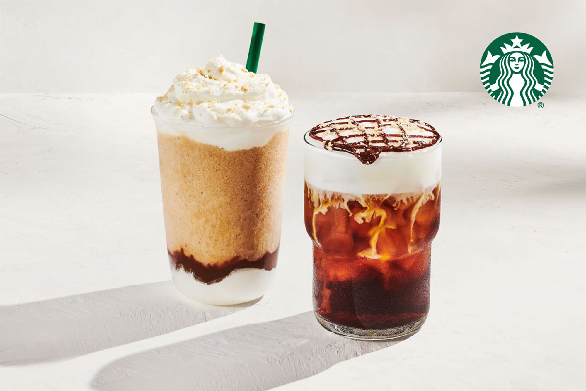 Two beverages are displayed: a blended drink topped with whipped cream and a chocolate drizzle, and a cold coffee drink layered with cream and a chocolate grid pattern on top.