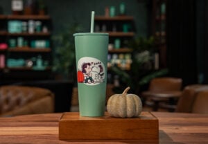 A green Linus and Snoopy coffee tumbler