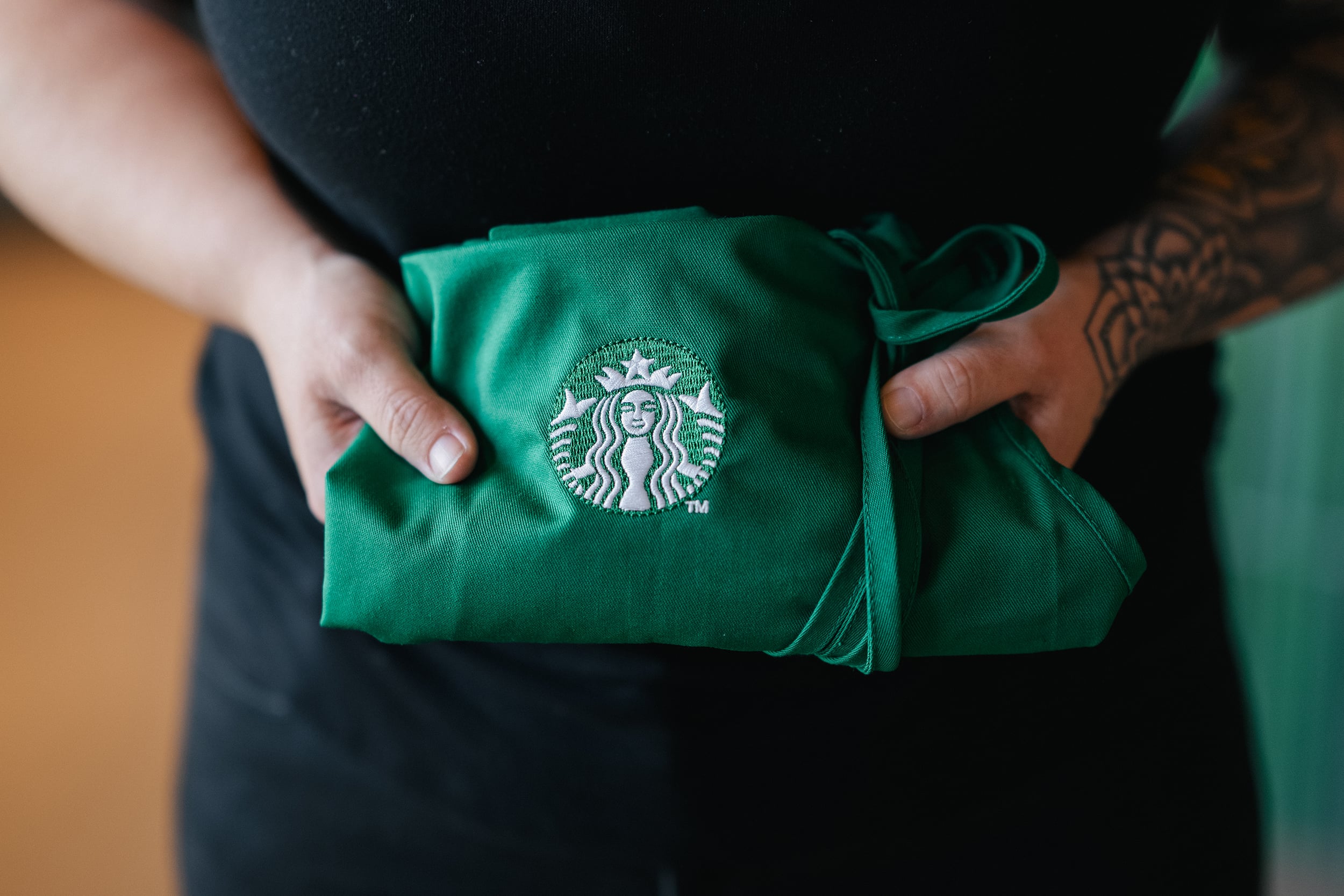 A Starbucks partner holding a folded apron