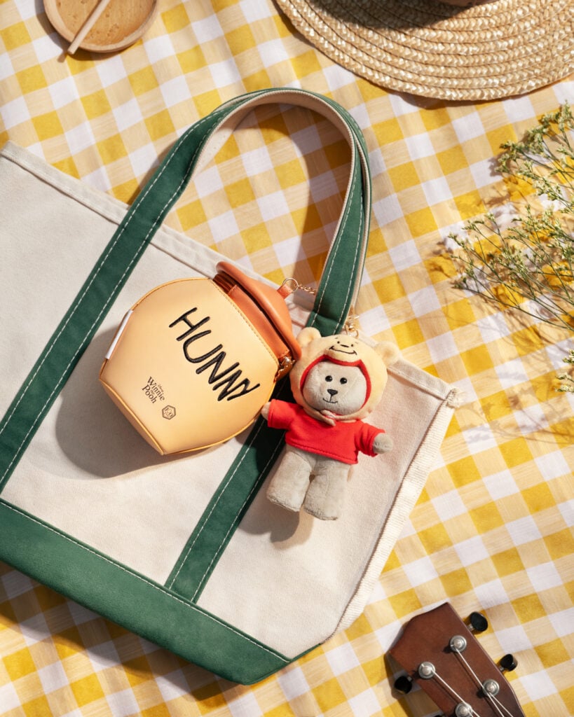 Starbucks Bearista dressed as Winnie the Pooh beside a honey-pot pouch